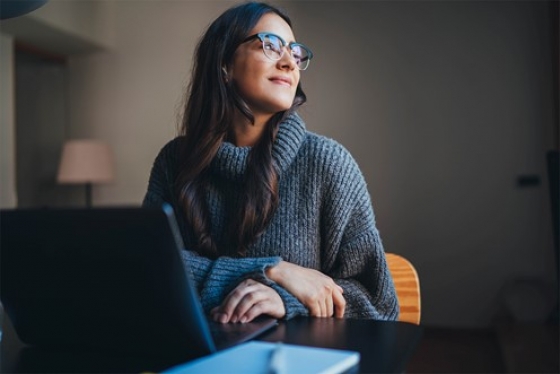 Pondering student looks away from computer