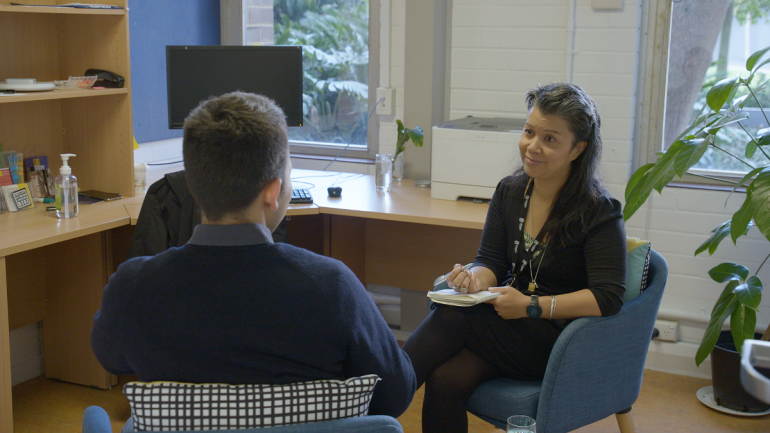 Image: two people sitting and talking