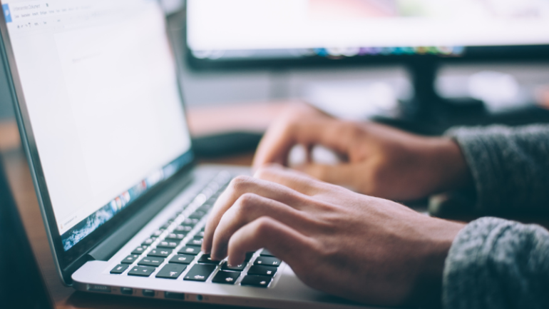 Person typing on laptop keyboard