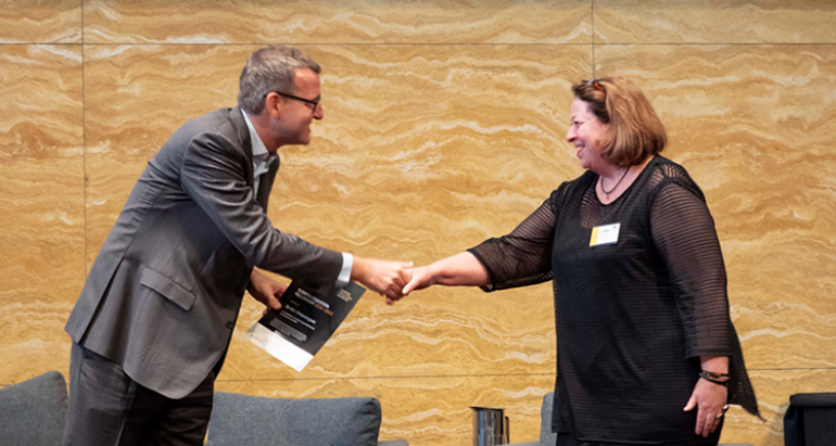 Academy Director Prof Chris Tisdell congratulates one of the newly-appointed Fellows, A/Prof Kim Snepvangers