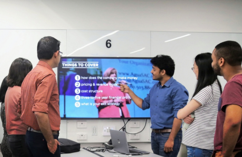 Students learning together, looking at a monitor