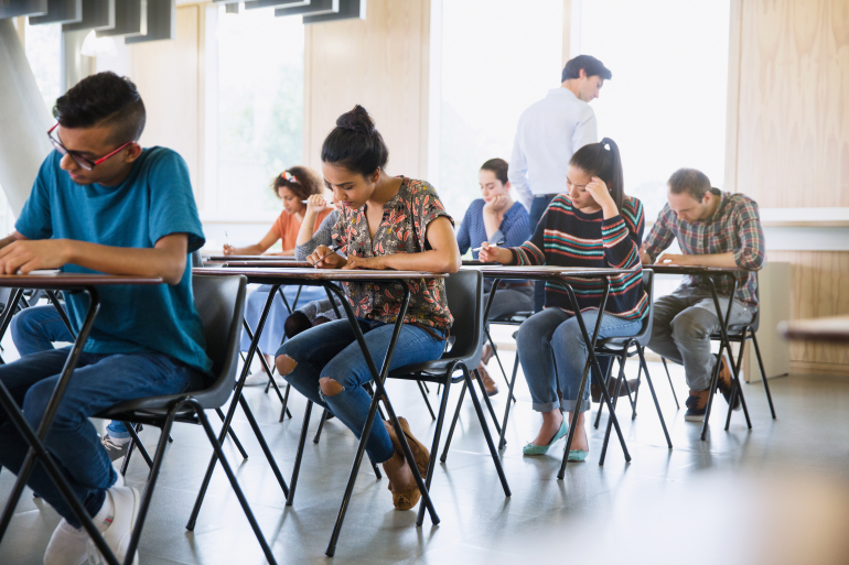 Students sitting at individual tables taking an exam