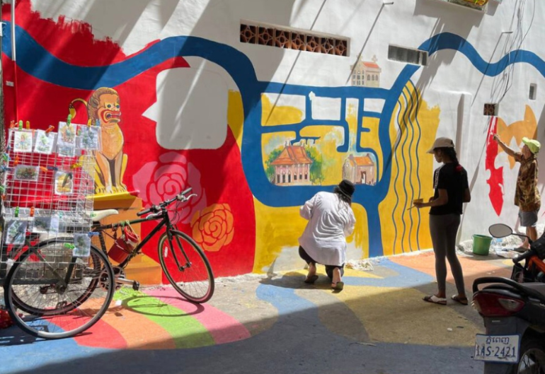 Student painting a mural in Cambodia