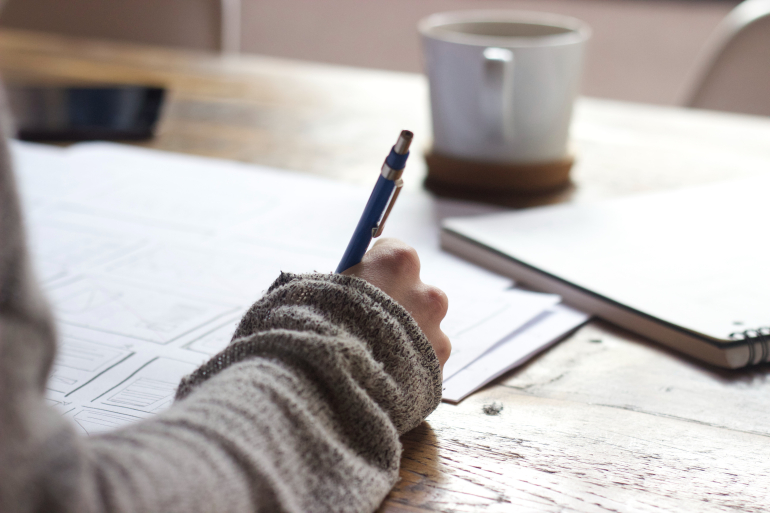 Person writing on table