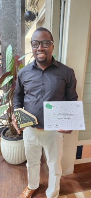 Dr Rotimi Abidoye holding his Dean’s Award for Outstanding Achievement as an Early Career Academic Educator 