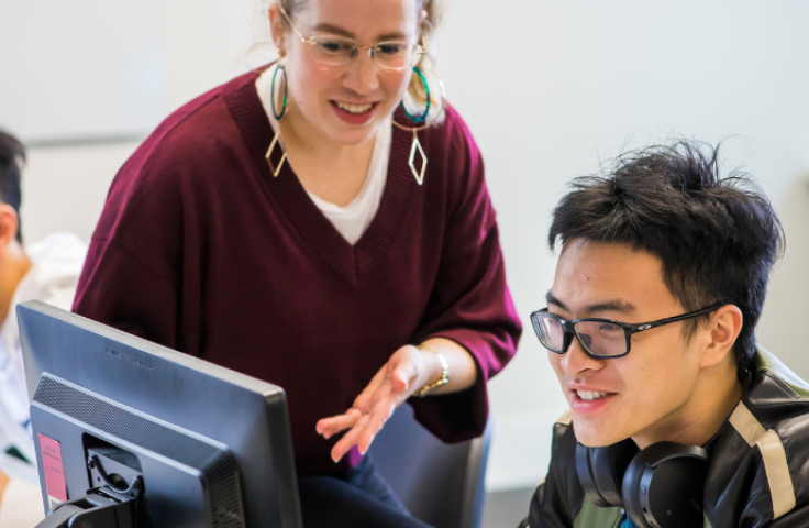 Student and teacher talking at computer UNSW