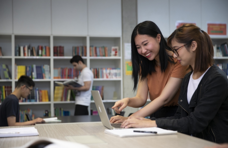 Two female students in library