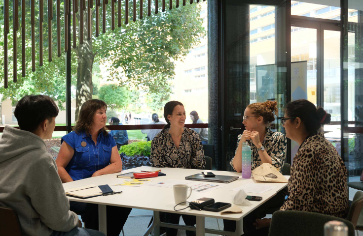 Group of staff chatting around a table
