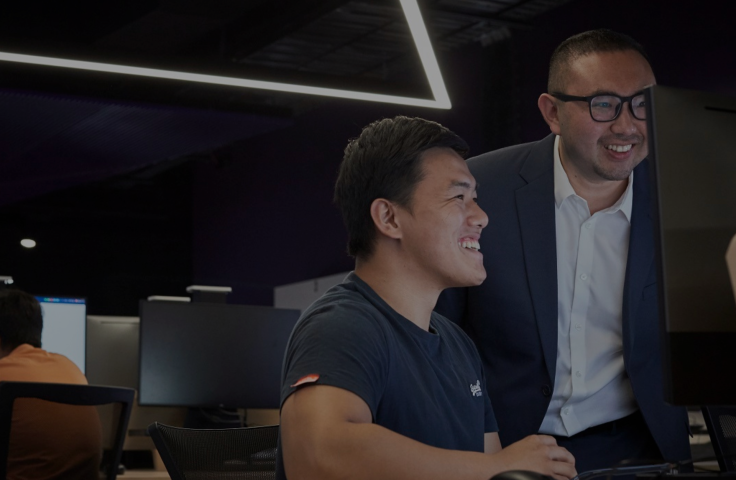 Student and teacher looking at a laptop