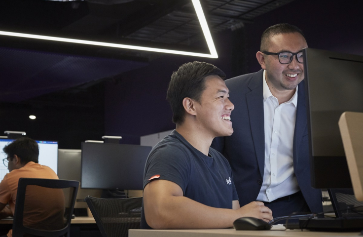 Student and teacher looking at a laptop