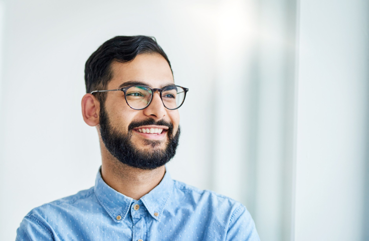 A man with glasses smiling
