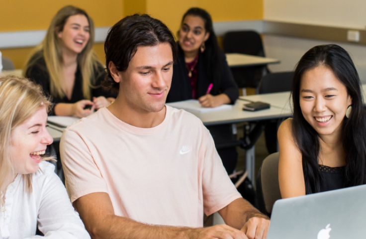 Three students looking at laptop