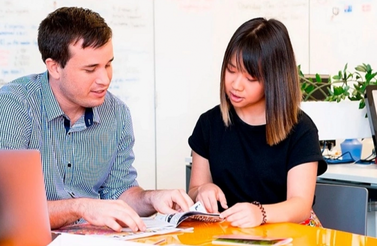 Photo of two students looking at documents