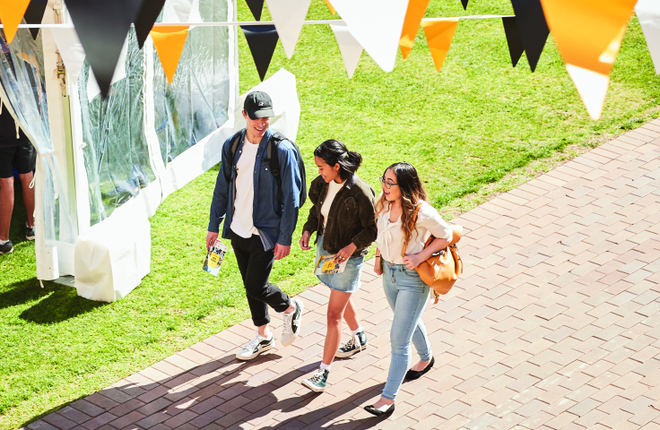 three students on main walkway on campus