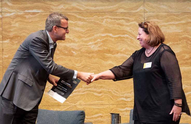 Academy Director Prof Chris Tisdell congratulates one of the newly-appointed Fellows, A/Prof Kim Snepvangers