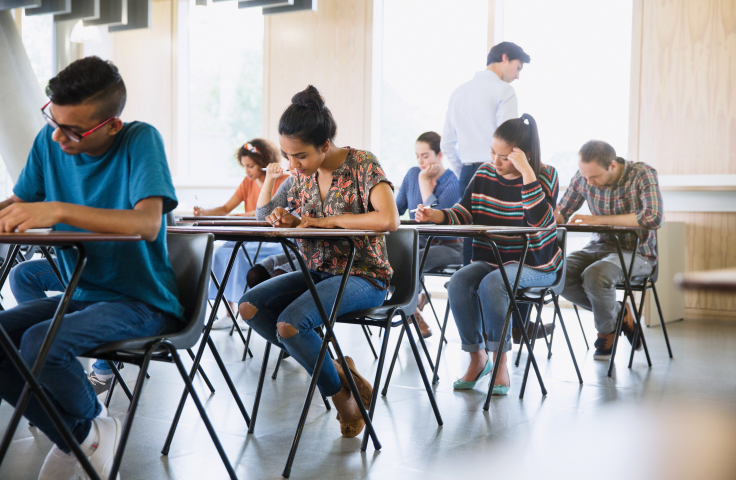 Students sitting at individual tables taking an exam