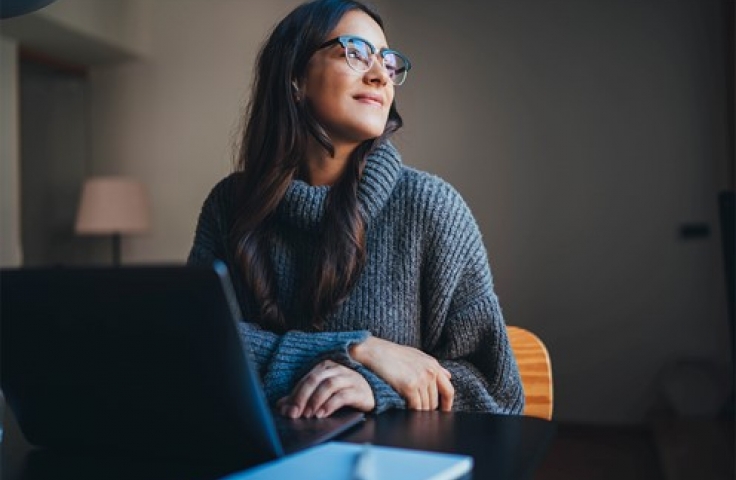 Pondering student looks away from computer