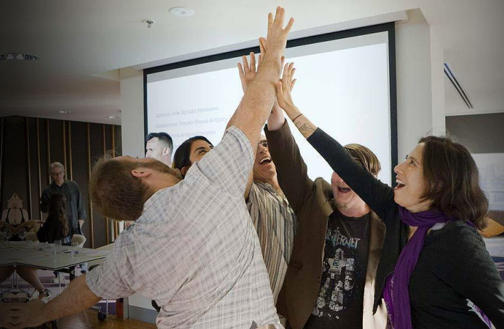 Colleagues high-five each other in an office setting