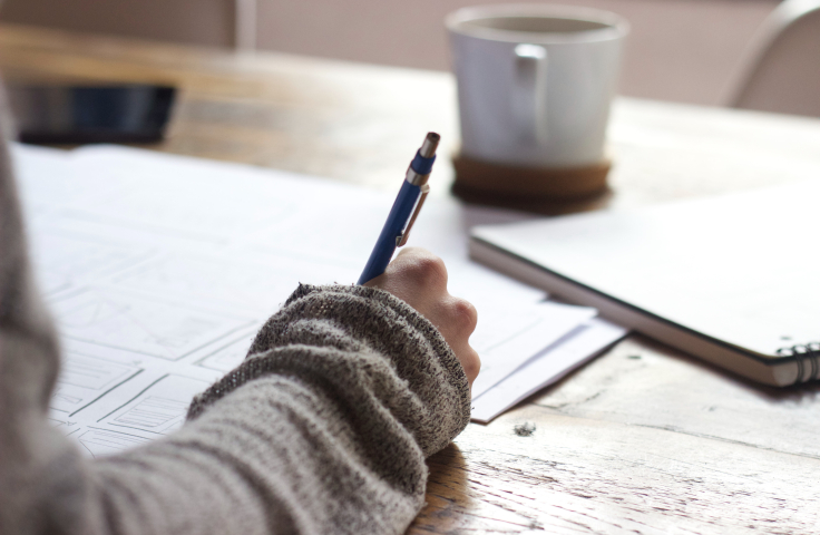 Person writing at desk